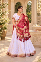 Noor ivory lehenga with maroon and gold ornate embroidered border, three-quarter view
